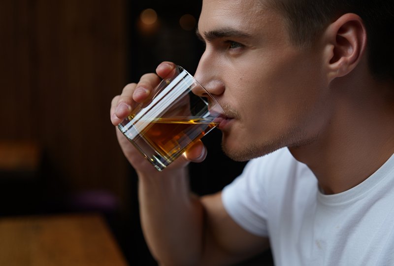 Человек пьет алкоголь